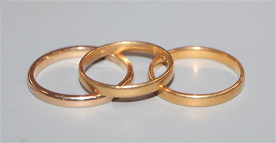 A 22ct gold wedding ring, an 18ct gold wedding ring and a yellow metal wedding ring.